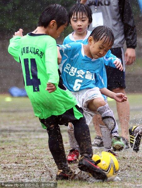 幻灯:韩国儿童享受足球乐趣 泥浆里混战也激情