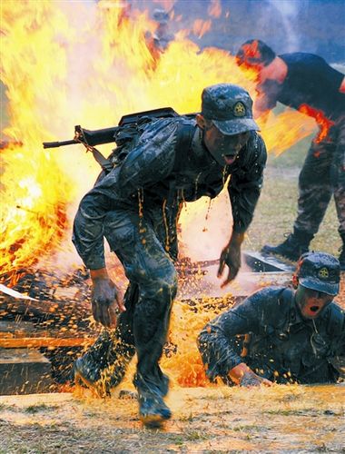 解放军报资料图:新战士在训练场上冲出火海.李华敏摄