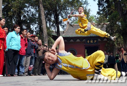 两名武校的小学员在少林寺山门前为游客们表演少林童子功(资料照片.