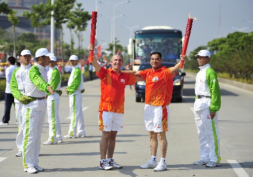 图文:亚运火炬在广东湛江传递 鲁希瑞与侯梓斌