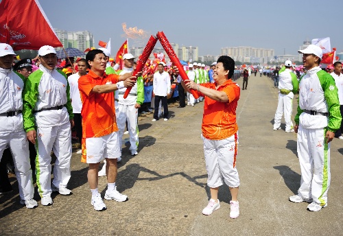 图文:亚运火炬在广东阳江传递 莫章德与江春燕