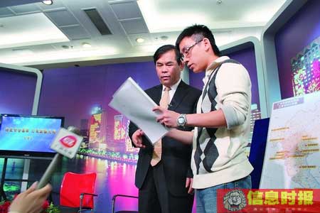 图为甘新副市长在与网友展开在线交流期间，甘新副市长（左）接收《网友关于广州市交通补助发放问题的意见》。大洋网供图