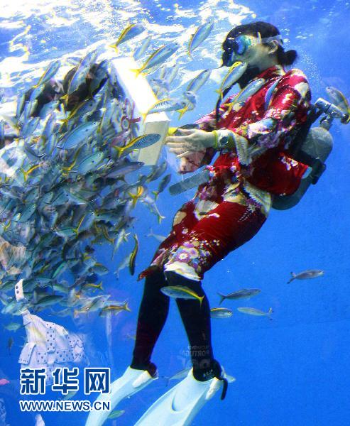 1月3日,在日本横滨一家水族馆,一名女潜水员穿着和服喂鱼,庆祝新年.