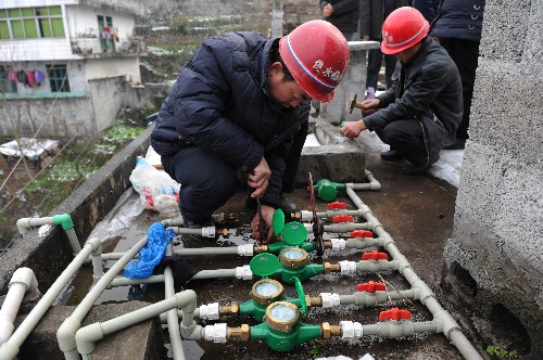 1月6日,自来水抢修队员在修理破损的水表