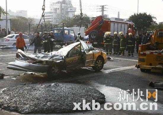 事故现场，吊车将被压出租车吊走。记者 毕志毅/摄