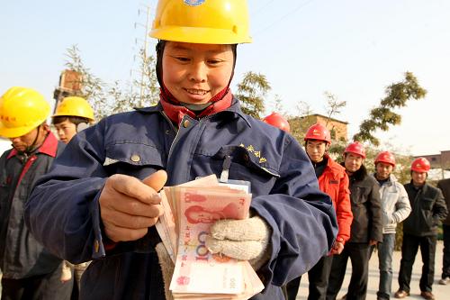 在安徽省淮北供电公司建设工地上,外来务工人员领到提前发放的工资