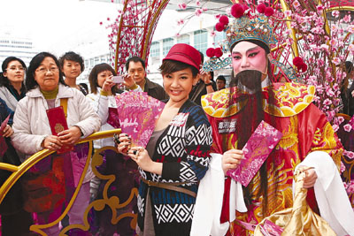 郑欣宜和财神一齐派利是给观众,让大家添财气.图片来源:香港文汇报