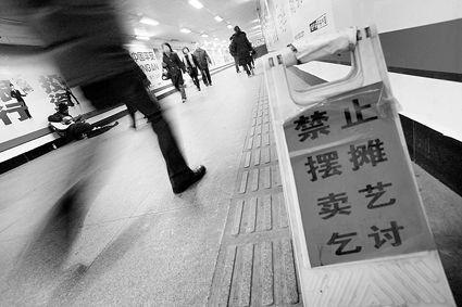 公主坟地铁里,城管部门贴出了"禁止摆摊卖艺乞讨"的告示