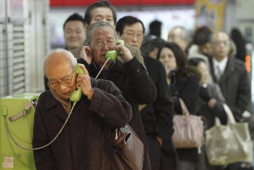 日本地震后,东京民众在地铁站的公共电话亭排队打电话