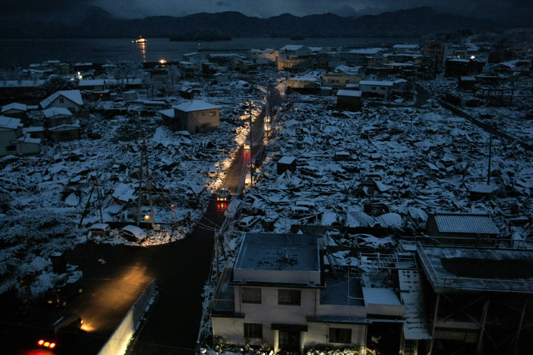 3月16日,在日本岩手县,车灯照亮山田灾区的一条街道 新华社/法新