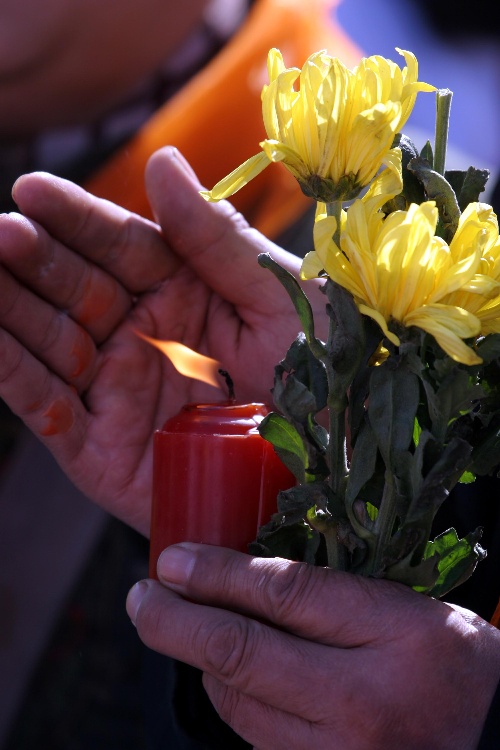 在沈阳西郊卧龙墓园,参加文明祭祀早春行动的市民手持蜡烛和菊花悼念
