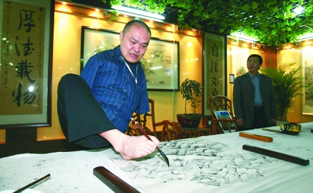 昨日,在九龙坡新建成的华岩奇人奇才艺术馆内,无臂口足画家黄国富亮起