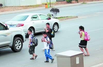 由于地下通道暂停使用,新天小学放学后学生们只能横穿马路,很不安全.