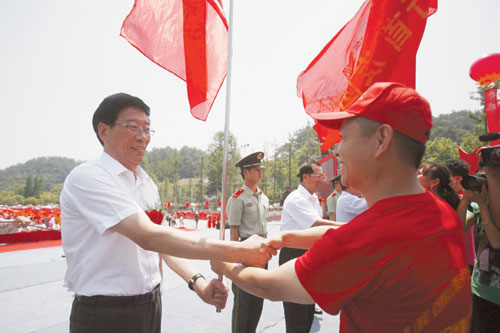 5月17日，韶山毛泽东广场，省委副书记、省长徐守盛（左）等领导向旗手授旗。 记者 武席同 摄