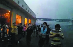 网民曝光的现场照片显示，厂房浓烟滚滚，里面充满火光，大批工人惊慌逃出厂房，有工人戴着口罩。网络截屏