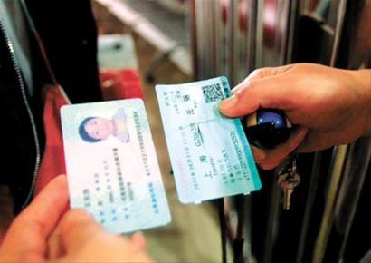 昨天,铁路上海站检票人员在查看g7062次旅客的身份证和实名车票.