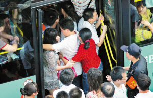 昨日,大梅沙内环路,两名乘客挽着手避免被挤下公交车.