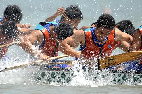 锦标赛在天津东疆海滩举行,一支参赛龙舟代表队的选手奋力划桨争先
