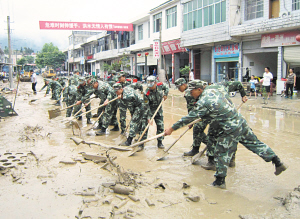 6月11日,在江西修水县白岭镇桃树村街道上全力清除淤泥.