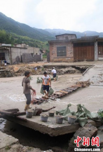6月14日,在江西修水县洪灾重白岭镇下太清村,几个村民在装填