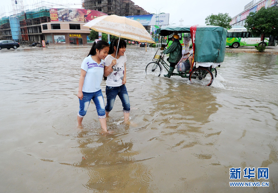 江西余干县两名学生在环城东路积水路面行走
