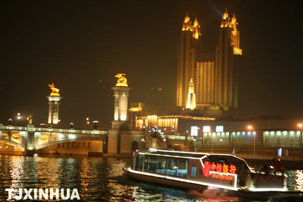 图为游客在游船上观赏天津海河狮子林桥的特色夜景.