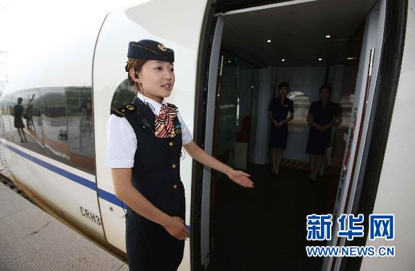 6月17日,在上海虹桥站站台上,高铁乘务员在引导乘客上车.