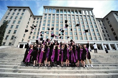 昨天,清华大学毕业生拍集体照时将帽子抛向天空. 记者张斌摄