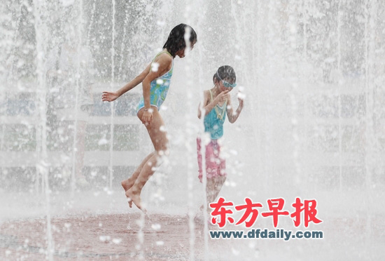 昨天,上海人民广场,两个身穿泳衣的女孩在喷泉里戏水.