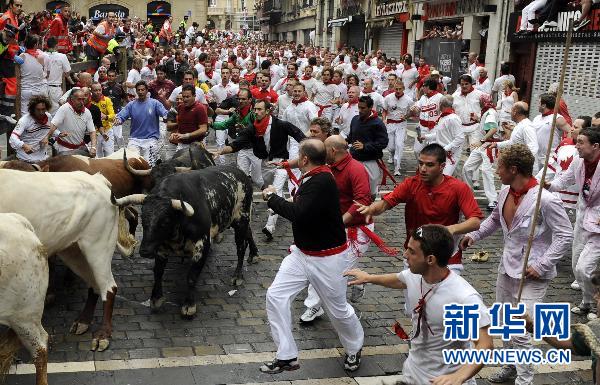 7月7日，在西班牙潘普洛纳市，人们参加街道奔牛活动。