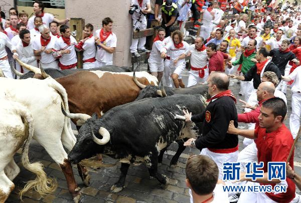 7月7日，在西班牙潘普洛纳市，人们参加街道奔牛活动。