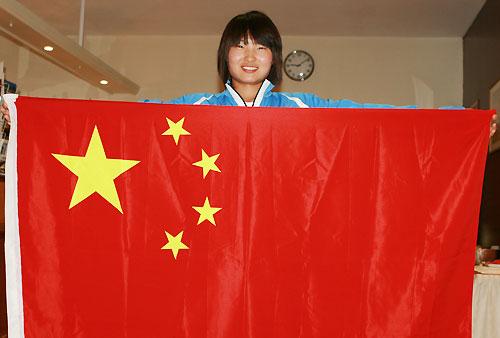图为毛艳雪在驻地手拿国旗