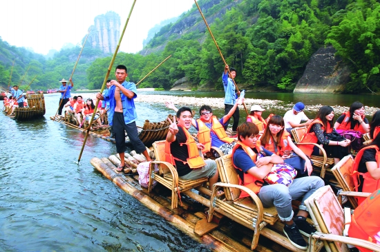 7月10日,众多游人乘竹筏在福建武夷山九曲溪漂流.