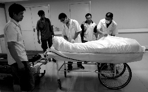 昨日,朝阳医院急诊室,医生和亲友将死者包裹好.本报记者 薛珺 摄