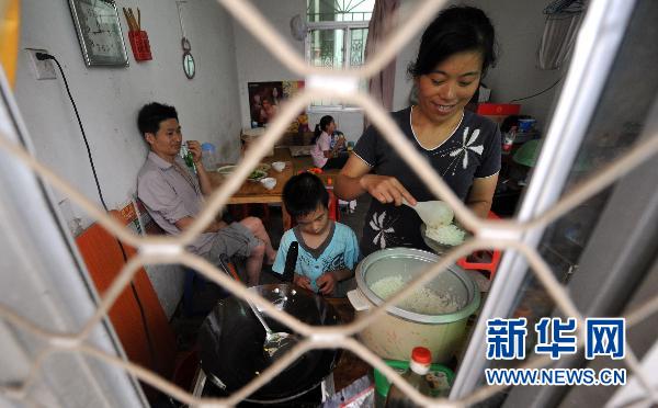 小辉妈妈握着小辉的手臂帮助他在训练课上完成画图任务（7月13日摄）。