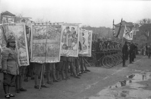 图为1941年1月29日,民众举着抗战漫画海报参加宣传大会及游行.