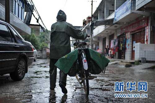 7月19日,罗细英冒着大雨骑车出发去送邮件。