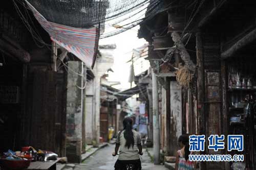 7月19日，罗细英骑着邮车经过陈坊乡的老街头。