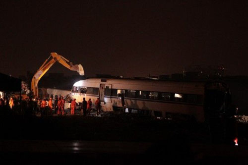 7月25日，挖掘机正在对事故列车车厢进行拆解。新华社记者 邢广利 摄