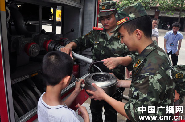 群众在排队接水（绵阳市公安消防支队 王二来 摄）