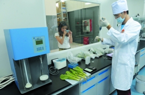 一家超市的工作人员正检测蔬菜是否有农药残留物。 首席摄影记者 吴宁/摄