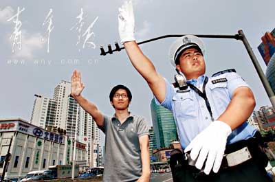 烈日下记者跟着交警学习交通指挥手势。