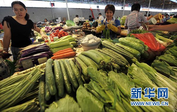 7月30日，市民正在海口市金龙市场购买蔬菜。受强热带风暴“洛坦”的影响，海口市部分蔬菜价格上涨。其中，胡萝卜、大白菜、四季豆等岛外蔬菜价格上涨明显，每斤上涨1至2元。新华社记者郭程摄