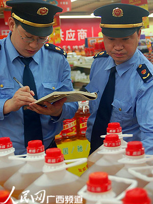 图为梧州市工商局执法人员在超市检查食用油