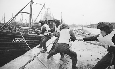 8日下午，辽宁丹东边防支队官兵协助渔船抛锚避风。