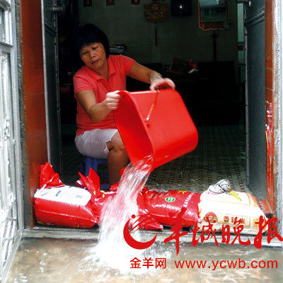 一名街坊用水桶往屋外倒水.