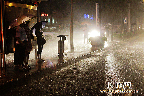 今天晚上雨中等待公交汽车的市民(孙占军 摄)