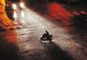 昆明西市区狂风大作大雨倾盆而下,夜归的骑车人顶风冒雨艰难前行记者