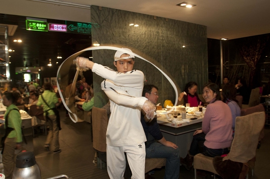 2010年12月4日,闵行一家海底捞火锅店,一名厨师正在为顾客表演拉面.