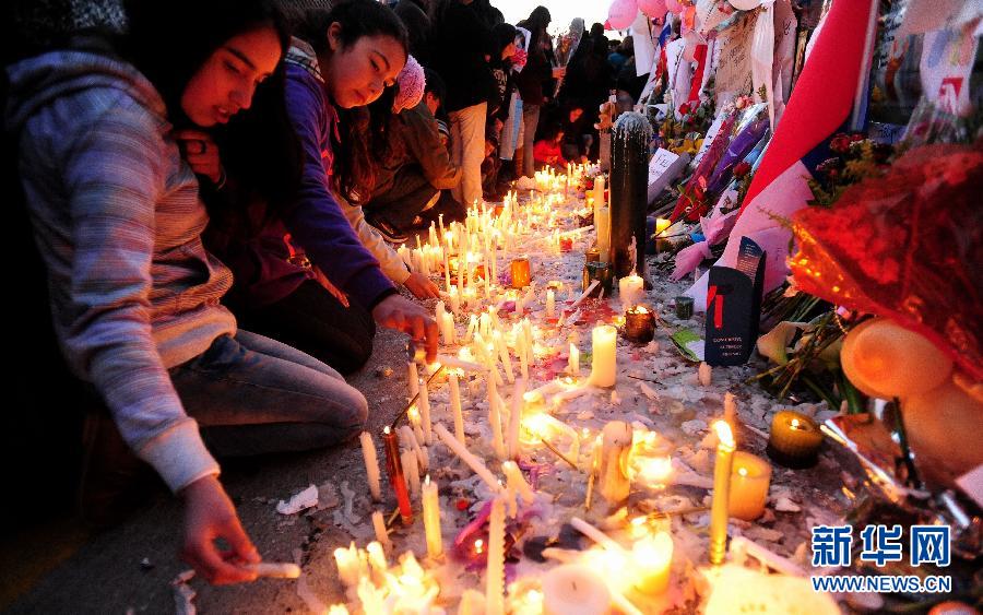 费利佩/9月4日，在智利首都圣地亚哥，人们在国家电视台大楼前燃起蜡烛...